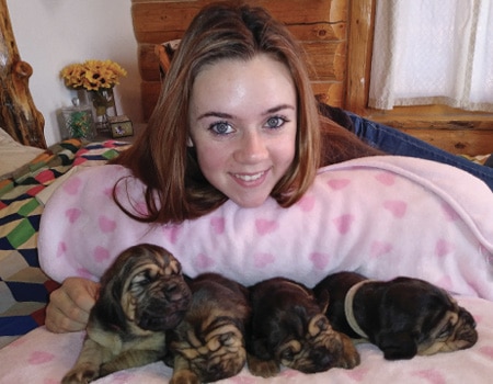 Karissa smiles with some pups from her recent litter.