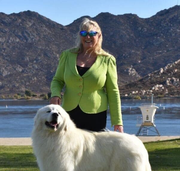 Terrie Strom standing with her Great Pyrenees dog