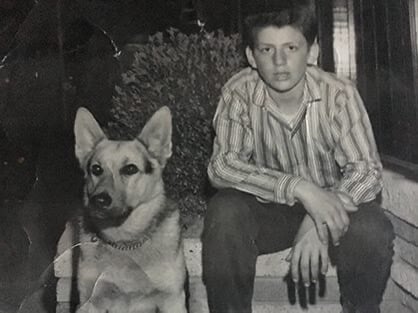 Young James Moses sitting with his German Shepherd Dog