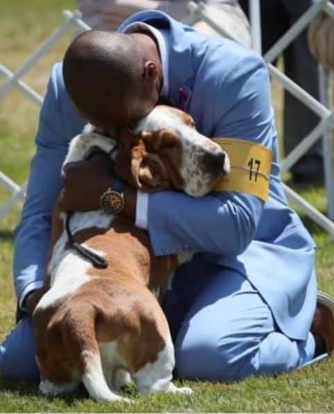 Man hugging a Basset Hound dog