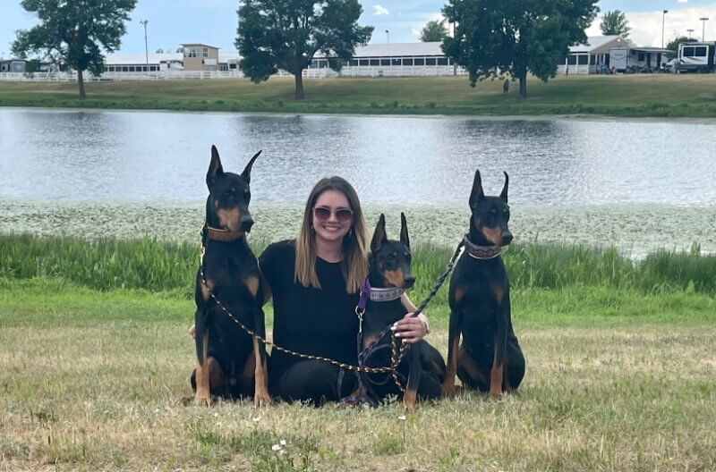 Ashlee Claggett with her Doberman Pinschers at the lake